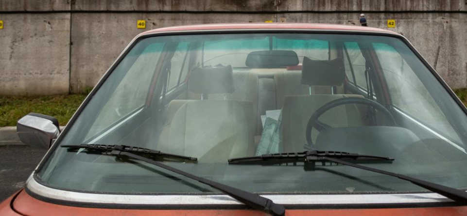 Front view of an old car’s windshield with wipers.